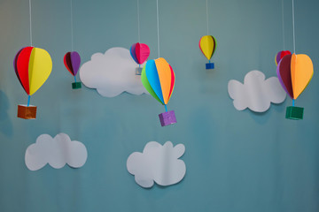 Hanging from above Colorful paper balloon with blue sky background and clouds. Origami made colorful air balloon cloud. - Powered by Adobe