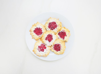 Homemade cookies with raspberry jam and fresh raspberries. Top view, space for text. Baking sweets at home.
