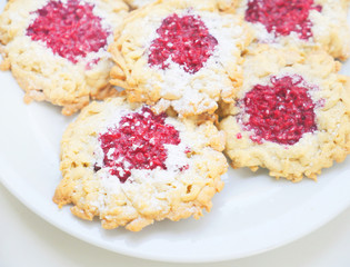 Homemade cookies with raspberry jam and fresh raspberries. Top view, space for text. Baking sweets at home.