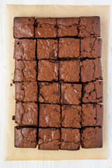 Homemade chocolate brownies on a baking sheet, overhead view. Top view, from above, flat lay. Closeup.