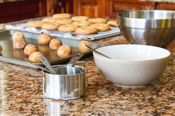 Cookies on a cookie sheet ready to go into oven and baked cookies cooling; fresh warm homemade snickerdoodles being baked