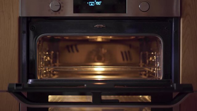 Person Places Tray Of Raw Fish To Cook In Oven