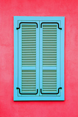 Blue wooden window frame. Pink red paint wall architecture background.