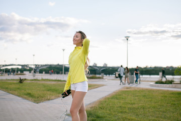 Cardio workout outdoors before running. Young european sensitive woman skipping rope. Exercising...