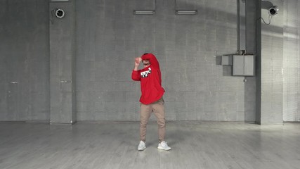 Stylish guy dancing hip-hop indoor. Young handsome guy in fashion casual clothes dancing break dance. Skillful dance performer.