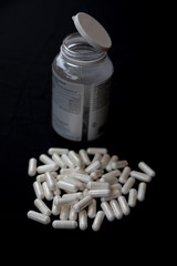 white pills on black background. medical pharmacy