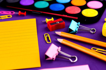 School office supplies stationery on a purple background desk with copy space. Back to school concept