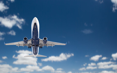 Fototapeta na wymiar Bottom View of Passenger Airplane Flying In The Blue Sky