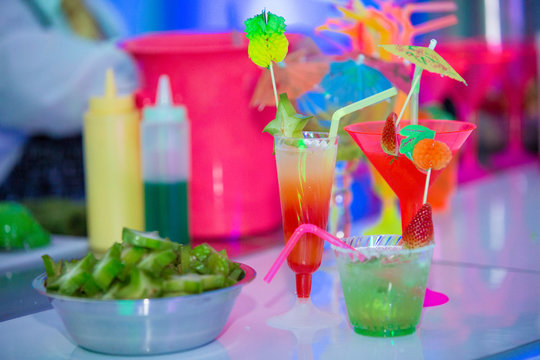 Colorful cocktail table with lemons and liquor. Spring break party concept. Summer tropical cocktails.