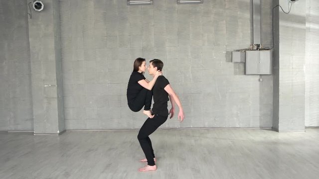 Couple of professional dancers training in modern studio. Young charismatic man and woman performing dance element. Great artistic potential.