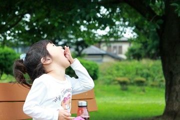 公園でおやつを食べる子供