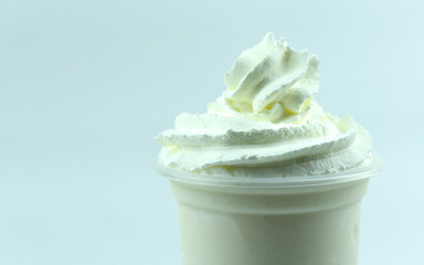 Close up Whipping cream on Fresh milk drink in a cool glass on white background, food concept front view.