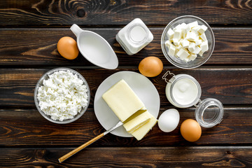 Dairy products from farm with milk, eggs, cottage, butter, yougurt on wooden background top view
