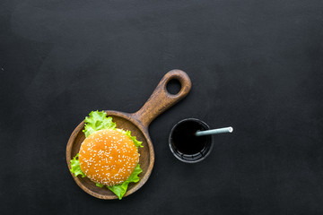Burger on pan and drink for national american kitchen concept on black background top view