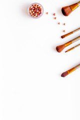 Brushes for make up, blusher on white visagiste work desk background top view copyspace