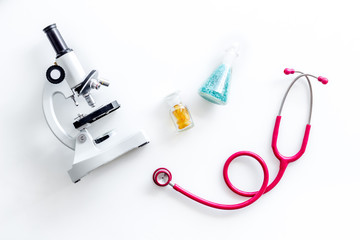 Medical research with microscope, stethoscope, test tube on white background top view