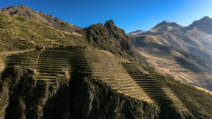 Aerial view of the ancient Inca ruins of Pisac (Pisaq) in the Sacred Valley near Cusco, Peru. Archaeological park with green terraces. - obrazy, fototapety, plakaty