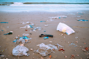 Trash, plastic, garbage, bottle, bag... environmental pollution on sandy beach. Royalty...