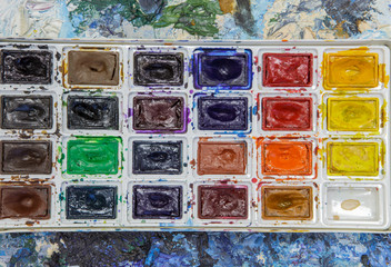 Old watercolor paint on a palette. Concept of art and creativity.