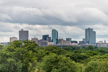 Fort Worth city in Texas with green trees in park and cityscape skyline and cloudy day