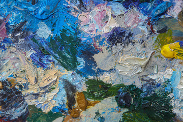 Abstract artistic background from an old palette with paints dried on it.