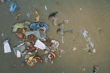 Trash, plastic, garbage, bottle, bag... environmental pollution on sandy beach. Royalty high-quality stock photo image of trash, plastic bag, bottle on the beach. Waste that polluted the ocean environ