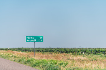 Brownfield, USA Texas countryside industrial town sign for Plains and Roswell New Mexico miles on...
