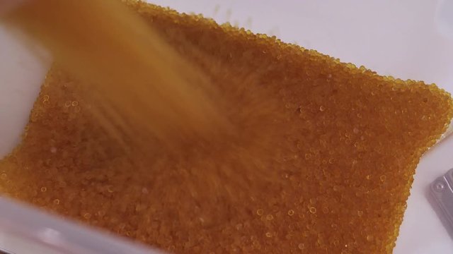 Pouring 1 kg of silica gel to a special plastic container.
