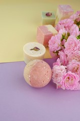 bath bombs set with rose extract and pink roses on a combined yellow lilac  background.Organic cosmetics for body