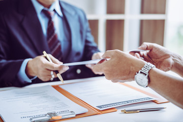 Group of middle age Asian business people and lawyers discussing and sign a contract.