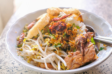 rice noodle with pork , bean sprouts, crispy pork skin, chili powder and clear soup is served at street food  in Chiangmai,  Thailand