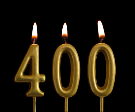 Golden birthday candles isolated on black background, number 400