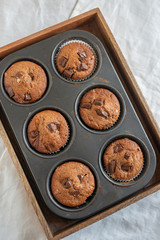 home made chocolate chip muffins in a muffin tray