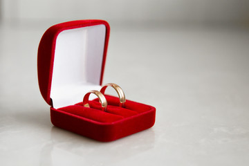 classic wedding rings in red boxing are on the white table. two golden wedding rings isolated on white, wedding rings background concept