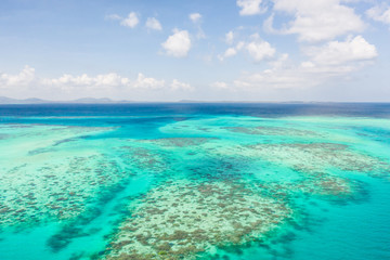 Coral reefs and atolls in the tropical sea, top view. Turquoise sea water and beautiful shallows. Philippine nature.