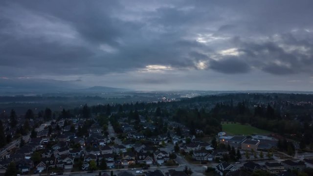 Aerial view of Residential homes in a modern city during a cloudy summer sunrise. Taken in Surrey, Vancouver, BC, Canada.