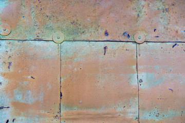 orange paint peeling off old metal strips. Old Metallic patchwork orange. Metal panels are peeling off paint. old metal sheets