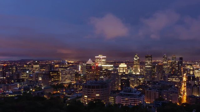 Aerial Time Lapse of a beautiful modern downtown city during a striking cloudy sunrise. Taken in Mt Royal, Montreal, Quebec, Canada.