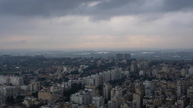 Aerial Time Lapse of a residential neighborhood in a city during a stormy cloudy sunrise. Taken in Netanya, Center District, Israel.