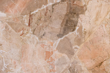 background of old cracked natural marble of red, yellow color with spots of different size and color
