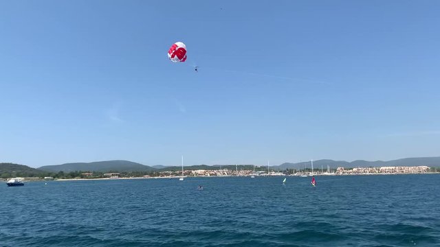 tourists fly by parachute over the sea