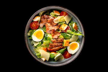 Top view image of caesar salad isolated at black background. - obrazy, fototapety, plakaty