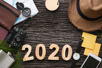 top view 2020 happy new year number on wood table with adventure accessory item,holiday vacation planning