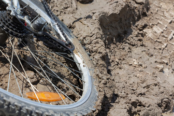 the Bicycle wheel is stuck in the mud. Close up