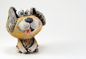 Clay figurine of a dog with his tongue sticking out.