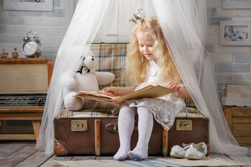 Little girl dressed as a princess plays in the room in the attic. © Alexandr Vasilyev
