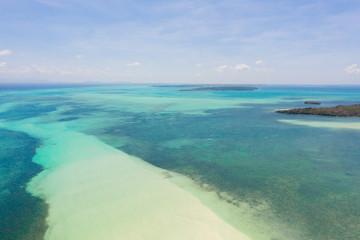 Coral reefs and atolls in the tropical sea, top view. Turquoise sea water and beautiful shallows. Philippine nature.