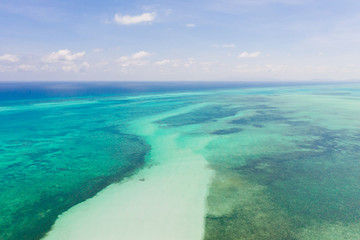 Fototapeta na wymiar Coral reefs and atolls in the tropical sea, top view. Turquoise sea water and beautiful shallows. Philippine nature.
