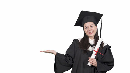Beautiful graduate student in mantle showing hand gesture side isolated on white background. smiling asian college girl wearing gown and cap holding diploma scroll face camera smiling introducing.