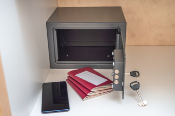 Opened metal safe in the hotel room, safe passport, credit cart and mobile phone